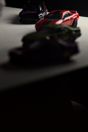 Mantua, Italy - 3RD JANUARY 2025 - Hot Wheels replicas of various Nissan Skyline models, two R30, a GT-R R32 and a GT-R R33, on a white board, next to a gray piece of fabric, pretending to have a race on a mountain road by the edge of a cliffのeditorial素材