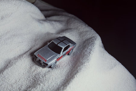 Mantua, Italy - 10TH JANUARY 2025 - Majorette replica of a Toyota Celica GT Coupe pretending to run a rally on a snowy road, next to a cliff, in the mountainsのeditorial素材