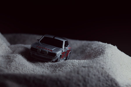 Mantua, Italy - 10TH JANUARY 2025 - Majorette replica of a Toyota Celica GT Coupe pretending to run a rally on a snowy road, next to a cliff, in the mountainsのeditorial素材