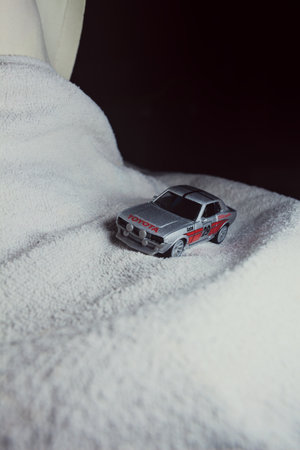 Mantua, Italy - 10TH JANUARY 2025 - Majorette replica of a Toyota Celica GT Coupe pretending to run a rally on a snowy road, next to a cliff, in the mountainsのeditorial素材