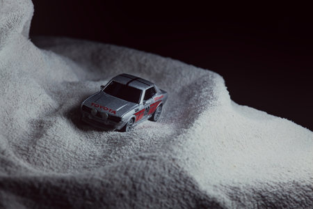 Mantua, Italy - 10TH JANUARY 2025 - Majorette replica of a Toyota Celica GT Coupe pretending to run a rally on a snowy road, next to a cliff, in the mountainsのeditorial素材