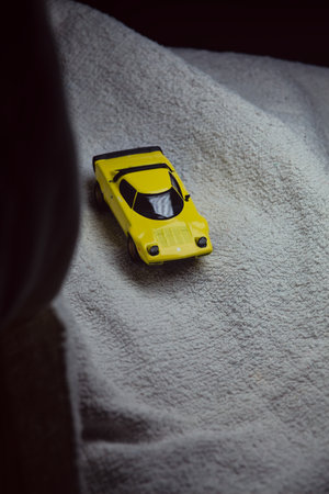 Mantua, Italy - 10TH JANUARY 2025 - Mini GT replica of a yellow Lancia Stratos HF Stradale pretending to run a rally on a snowy road, next to a cliff, in the mountainsのeditorial素材