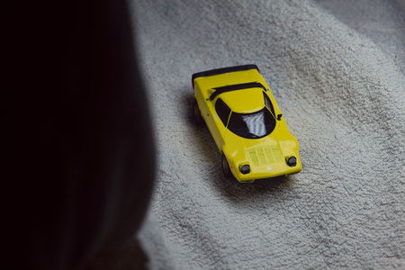 Mantua, Italy - 10TH JANUARY 2025 - Mini GT replica of a yellow Lancia Stratos HF Stradale pretending to run a rally on a snowy road, next to a cliff, in the mountainsのeditorial素材