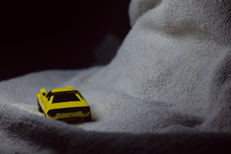 Mantua, Italy - 10TH JANUARY 2025 - Mini GT replica of a yellow Lancia Stratos HF Stradale pretending to run a rally on a snowy road, next to a cliff, in the mountainsのeditorial素材