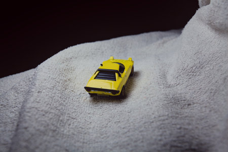 Mantua, Italy - 10TH JANUARY 2025 - Mini GT replica of a yellow Lancia Stratos HF Stradale pretending to run a rally on a snowy road, next to a cliff, in the mountainsのeditorial素材