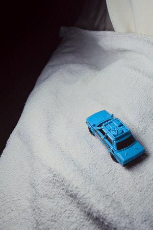 Mantua, Italy - 10TH JANUARY 2025 - Matchbox replica of a 1970 Datsun 510 in rally livery and trim pretending to run a rally on a snowy road, next to a cliff, in the mountainsのeditorial素材