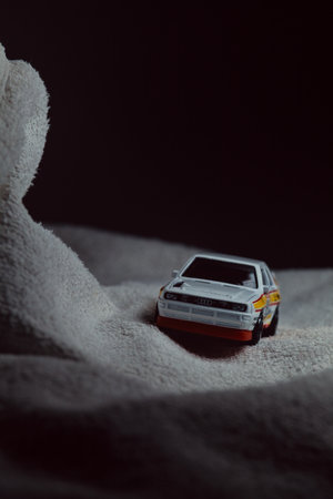 Mantua, Italy - 10TH JANUARY 2025 - Hot Wheels replica of a 1984 Audi Sport Quattro in rally livery and trim pretending to run a rally on a snowy road, next to a cliff, in the mountainsのeditorial素材