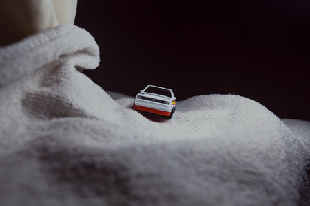Mantua, Italy - 10TH JANUARY 2025 - Hot Wheels replica of a 1984 Audi Sport Quattro in rally livery and trim pretending to run a rally on a snowy road, next to a cliff, in the mountainsのeditorial素材