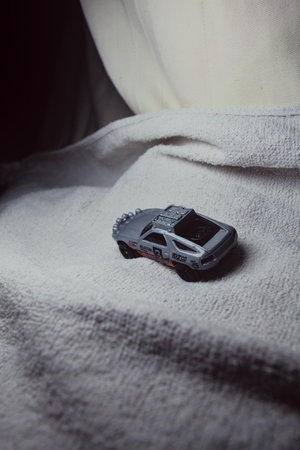 Mantua, Italy - 10TH JANUARY 2025 - Hot Wheels replica of a Porsche 928S Safari in rally livery and trim pretending to run a rally on a snowy road, next to a cliff, in the mountainsのeditorial素材