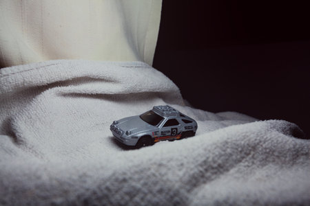 Mantua, Italy - 10TH JANUARY 2025 - Hot Wheels replica of a Porsche 928S Safari in rally livery and trim pretending to run a rally on a snowy road, next to a cliff, in the mountainsのeditorial素材