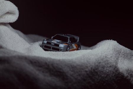 Mantua, Italy - 10TH JANUARY 2025 - Hot Wheels replica of an Audi 90 Quattro pretending to run a rally on a snowy road, next to a cliff, in the mountainsのeditorial素材