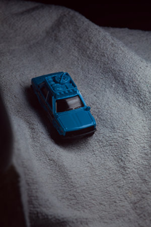 Mantua, Italy - 10TH JANUARY 2025 - Matchbox replica of a 1970 Datsun 510 in rally livery and trim pretending to run a rally on a snowy road, next to a cliff, in the mountainsのeditorial素材