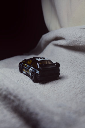 Mantua, Italy - 10TH JANUARY 2025 - Hot Wheels replica of a Ford Escort in black livery and rally trim pretending to run a rally on a snowy road, next to a cliff, in the mountainsのeditorial素材