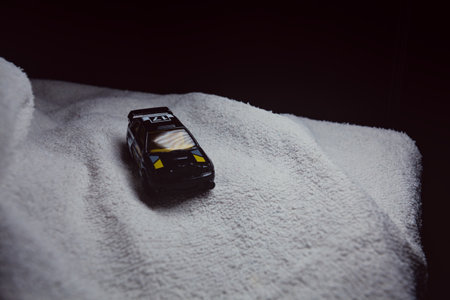 Mantua, Italy - 10TH JANUARY 2025 - Hot Wheels replica of a Ford Escort in black livery and rally trim pretending to run a rally on a snowy road, next to a cliff, in the mountainsのeditorial素材