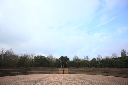 Paved square in a park, with staircases surrounding it, on a cloudy day in winter
