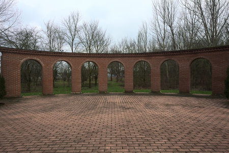 Colonnade at one end of a square, with a park behind, on a cloudy day in winterの写真素材