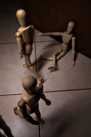 Wooden mannequins arranged in a scene where one appears to be sitting and reaching out towards...