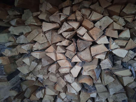 Chopped stacked firewood is lying in the shedの写真素材