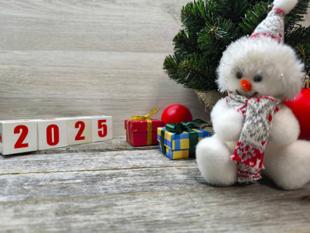 New Year snowman near the Christmas tree. The numbers 2025 are next to itの写真素材