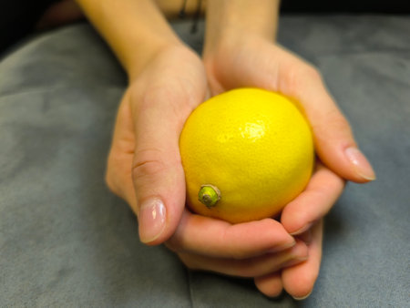 Hands holding a fresh lemon