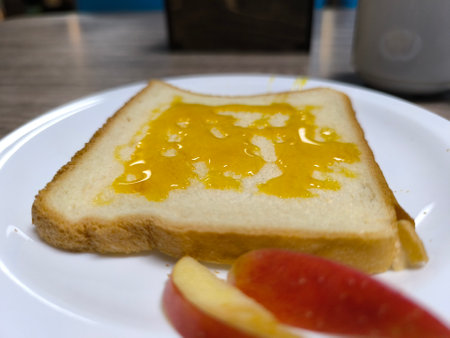 Fried white bread doused with honey on a white plate.