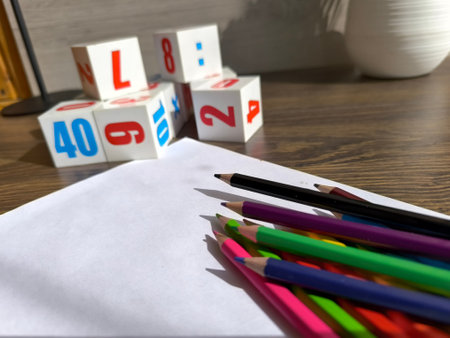 Cubes with numbers, pencils and a white sheet of paper on the table. High-quality photosの写真素材