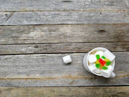 beautiful, airy, pale white marshmallow with colorful candied fruits in a white cup. view from aboveの写真素材