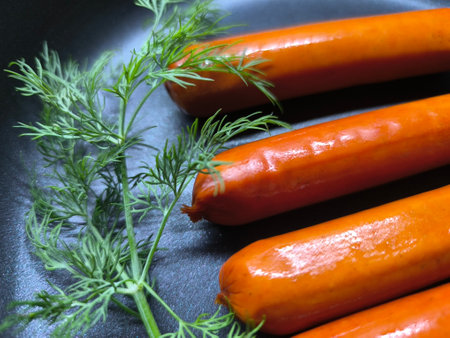 Grilled sausages with herbs are fried in a frying pan. High quality photoの写真素材
