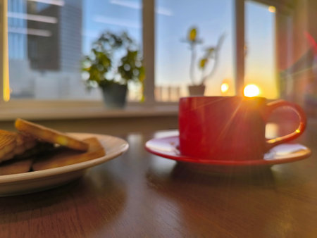 red cup on the office table illuminated by the morning sun.の写真素材