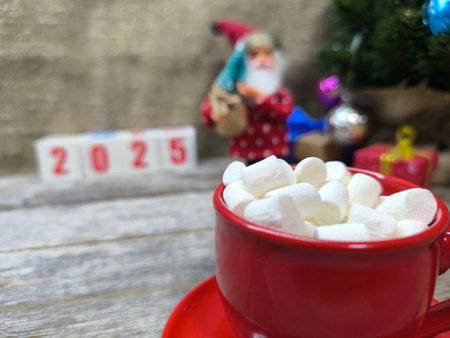 cup with pieces of marshmallows, in the background a Christmas and New Year composition with the...