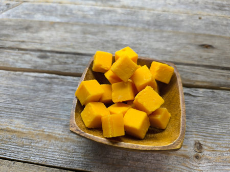 Diced cheese lies in a wooden plateの写真素材