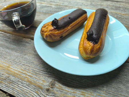 Delicious eclairs on a plate close-up with chocolateの写真素材