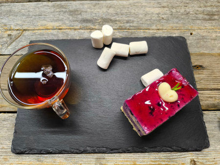 tender juicy blueberry cake lies on a granite board next to marshmallows and a cup of teaの写真素材
