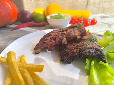fried ribs on a white plate with French fries. High-quality photosの写真素材