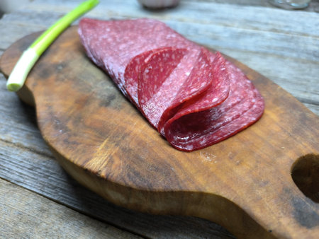 sliced ââsalami lies on a wooden boardの写真素材