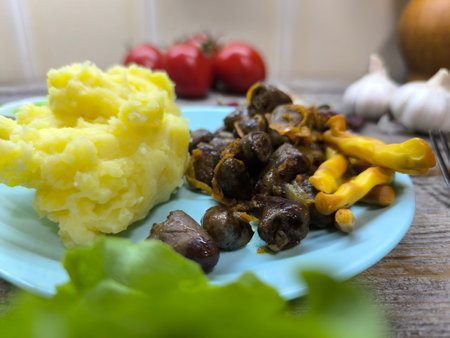 Chicken hearts with mashed potatoes on a plate surrounded by greens and vegetables. Restaurant food. Food style and serving dishes in a restaurant.の写真素材