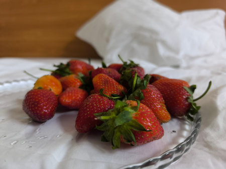 Group of strawberries lying on white bed sheetの写真素材