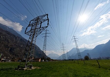 High-voltage pylons at the end of the day on a background of blue sky