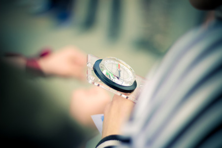 The photo of a compass a close up which is held in hand