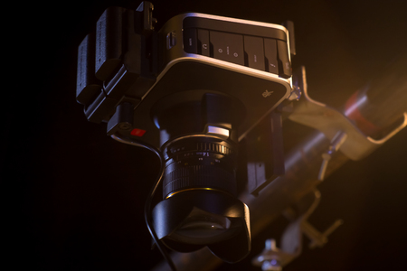 The evening photo of the video camera which is hanging on a metal pipe and removing from above in a bottomの写真素材