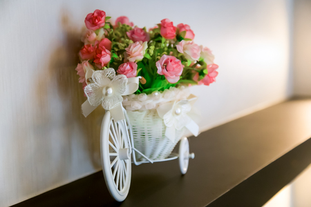 Decorative basket with flowers in the form of the bicycle standing on a pedestalの写真素材
