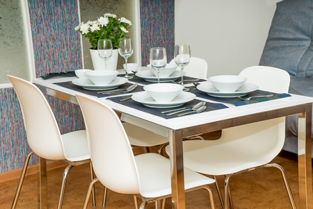The laid table in hotel kitchen with glasses, tableware and platesの写真素材