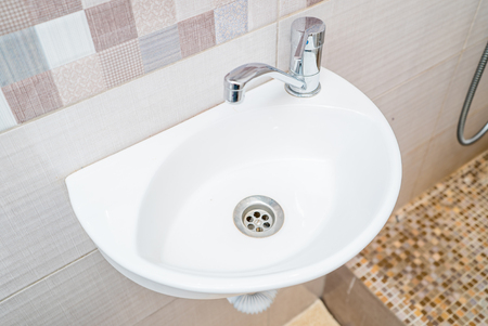 The photo of a white clean sink with the crane in the bathroomの写真素材