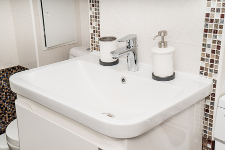 The photo of a white clean sink with the crane in the bathroomの写真素材