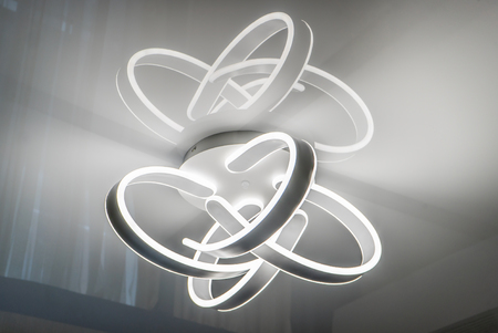 Decorative bright chandelier of irregular shape in modernist style weighing on a ceilingの写真素材