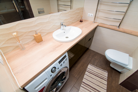 The photo of the light white bathroom with household appliancesの写真素材