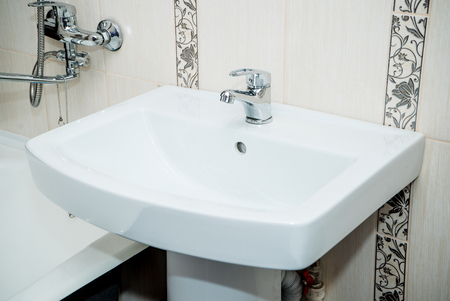 The photo of a white clean sink with the crane in the bathroomの写真素材