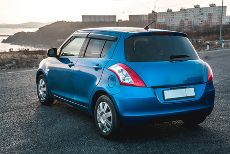 The photo of the blue car standing on the roadの写真素材