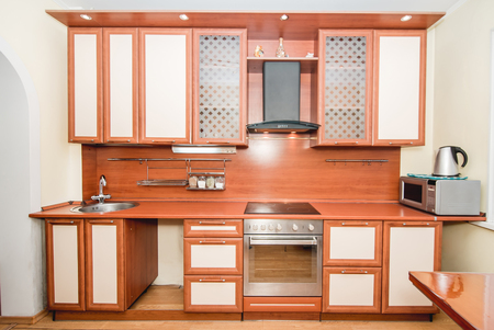 The photo of completely equipped light kitchen with household appliancesの写真素材