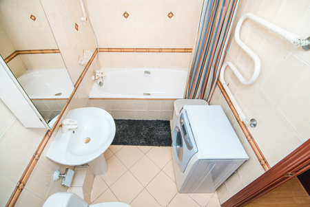 The photo of the light white bathroom with household appliancesの写真素材
